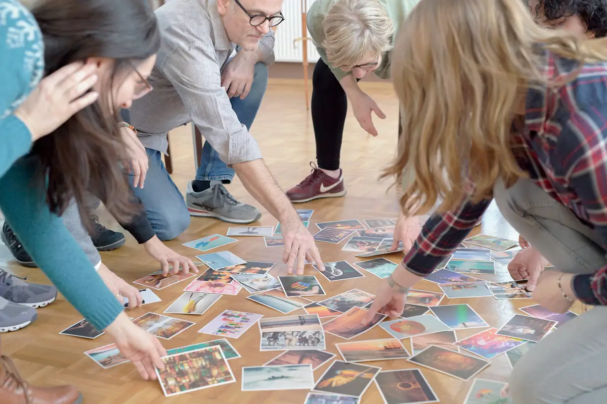 Gruppe von Menschen wählt Bildkarten für eine Coaching-Übung